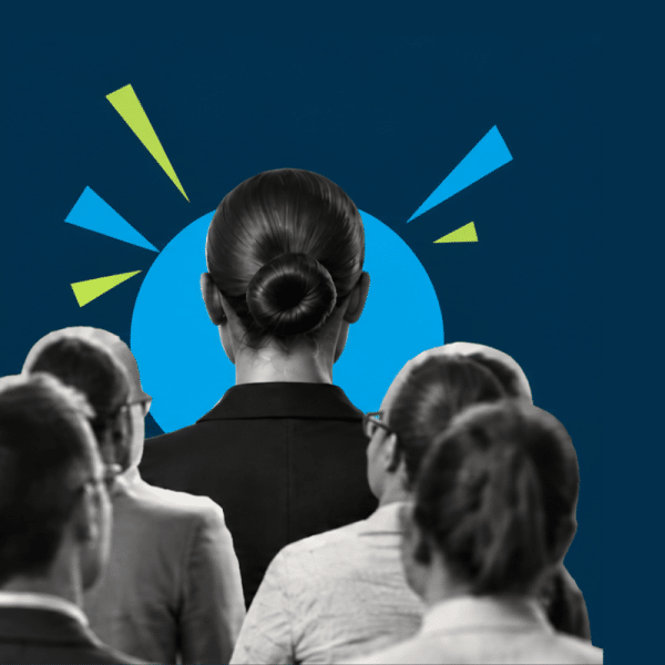 Audience of professionals facing a speaker on stage with a blue circular backdrop and decorative shapes